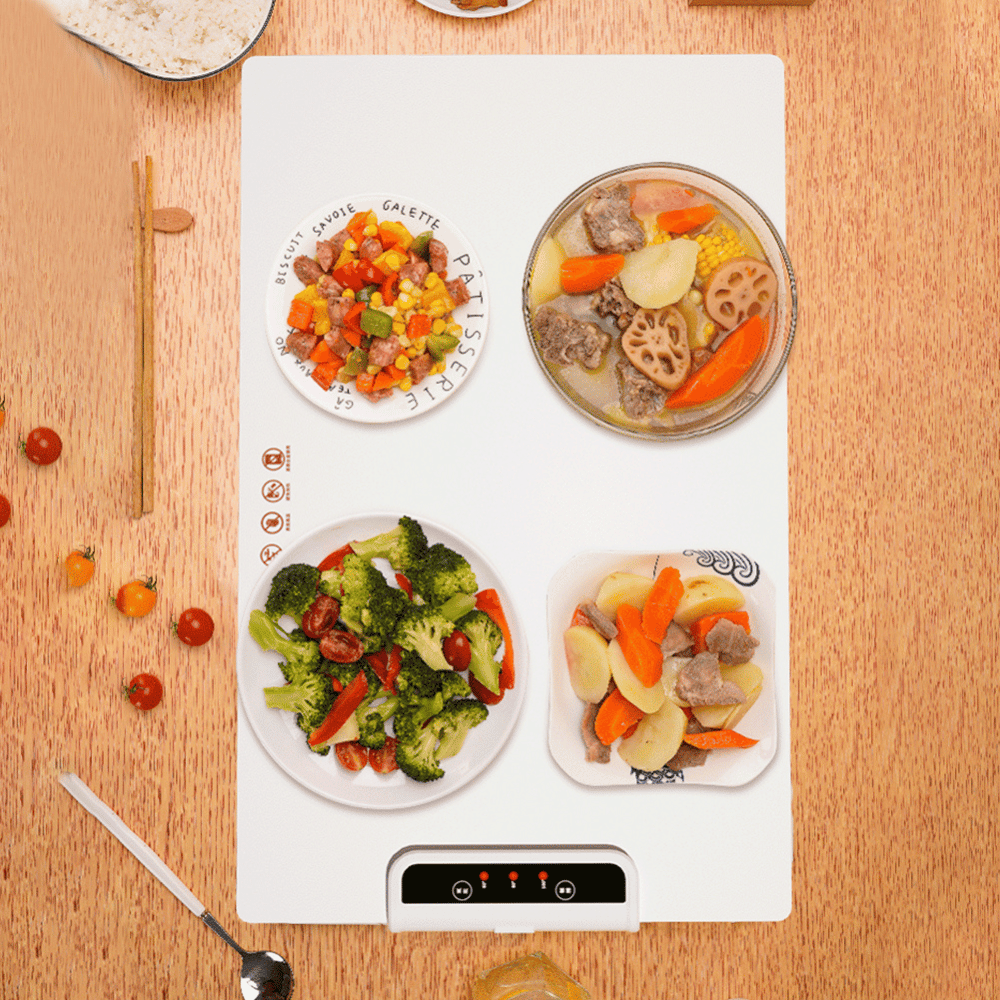 Heating mat with plates of food on a wooden surface