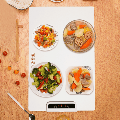 Heating mat with plates of food on a wooden surface